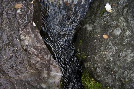 Small water stream in between two rocks in autumn