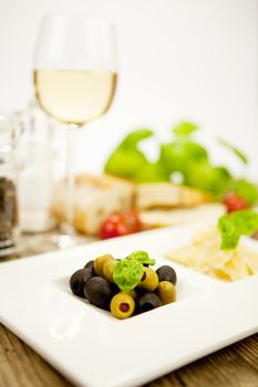 deliscious antipasti plate with parma parmesan olives on wooden background