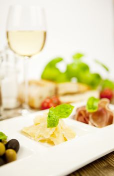 deliscious antipasti plate with parma parmesan olives on wooden background