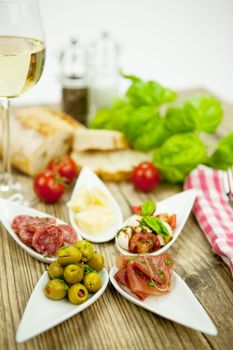 deliscious antipasti plate with parma parmesan olives on wooden background
