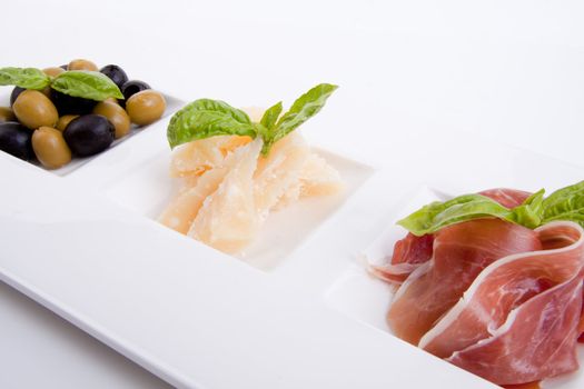 deliscious antipasti plate with parma parmesan and olives isolated on white background