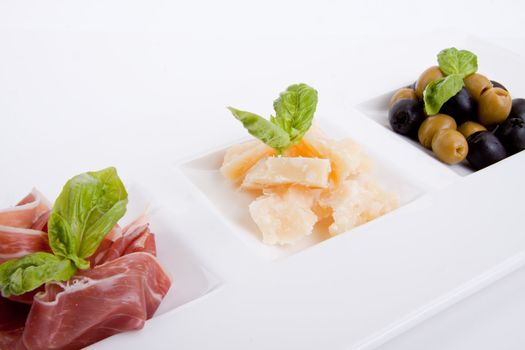 deliscious antipasti plate with parma parmesan and olives isolated on white background