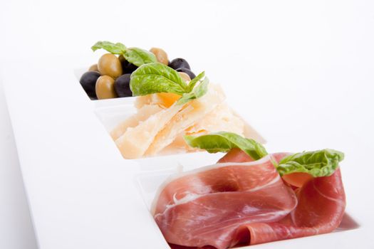 deliscious antipasti plate with parma parmesan and olives isolated on white background