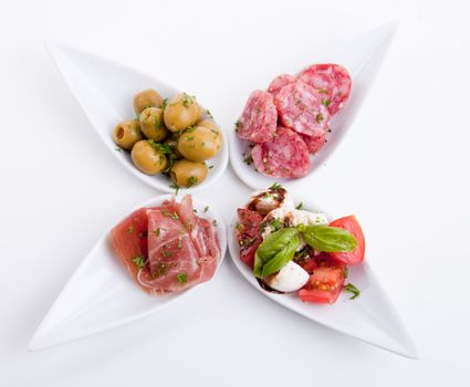 deliscious antipasti plate with parma parmesan and olives isolated on white background