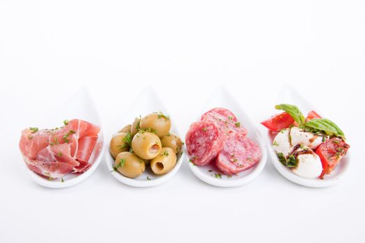 deliscious antipasti plate with parma parmesan and olives isolated on white background