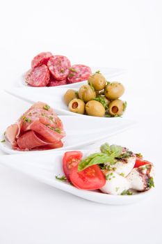 deliscious antipasti plate with parma parmesan and olives isolated on white background