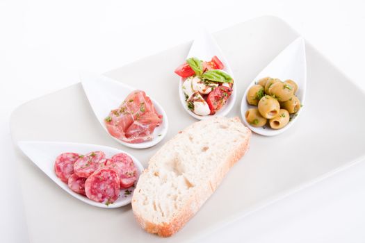 deliscious antipasti plate with parma parmesan and olives isolated on white background