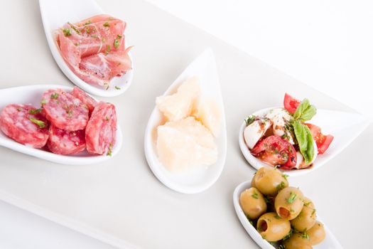 deliscious antipasti plate with parma parmesan and olives isolated on white background