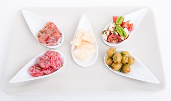 deliscious antipasti plate with parma parmesan and olives isolated on white background