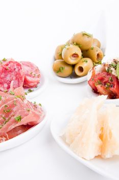 deliscious antipasti plate with parma parmesan and olives isolated on white background