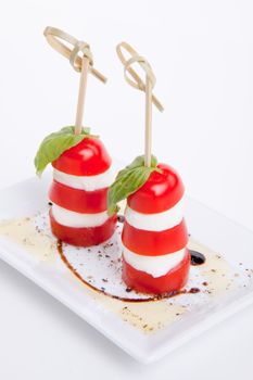 tasty tomatoe mozarella salad with basil isolated on white background
