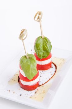 tasty tomatoe mozarella salad with basil isolated on white background