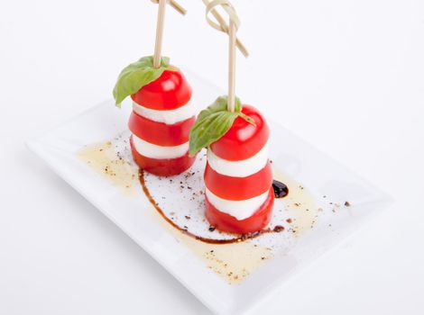 tasty tomatoe mozarella salad with basil isolated on white background