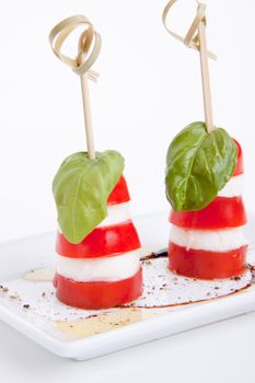 tasty tomatoe mozarella salad with basil isolated on white background