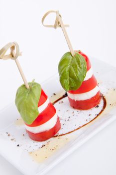 tasty tomatoe mozarella salad with basil isolated on white background