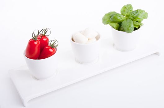 tasty tomatoe mozarella salad with basil isolated on white background