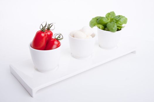 tasty tomatoe mozarella salad with basil isolated on white background