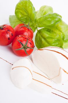 tasty tomatoe mozarella salad with basil isolated on white background