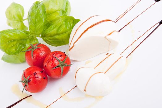 tasty tomatoe mozarella salad with basil isolated on white background