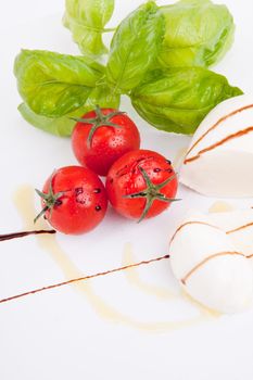 tasty tomatoe mozarella salad with basil isolated on white background