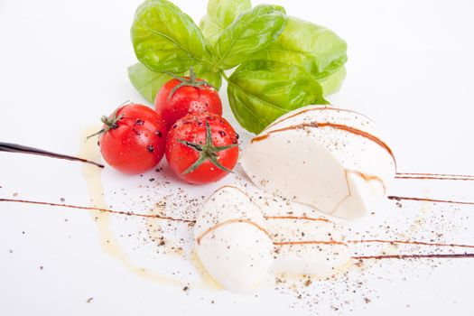 tasty tomatoe mozarella salad with basil isolated on white background