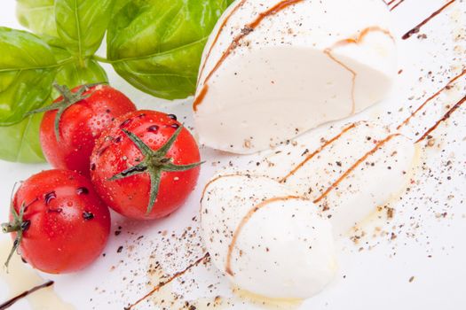 tasty tomatoe mozarella salad with basil isolated on white background