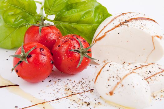 tasty tomatoe mozarella salad with basil isolated on white background