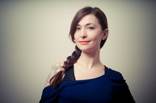 portrait of beautiful girl with long hair and blue sweater on gray background