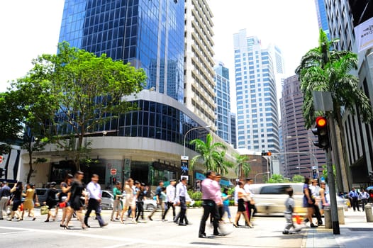 Singapore, Republic of Singapore - March 07, 2013: Unidentified businessmen crossing the street on March 07, 2013 in Singapore. There are more than 7,000 multinational corporations from United States, Japan and Europe in Singapore. 