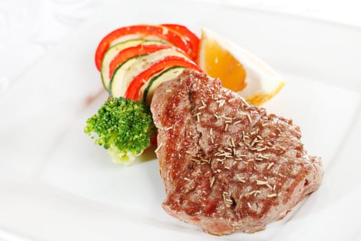 Steak with vegetables on white plate 