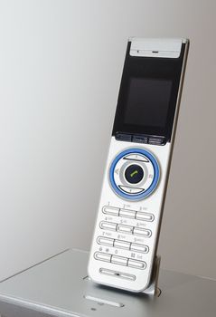A used modern landline phone in front of a white background.