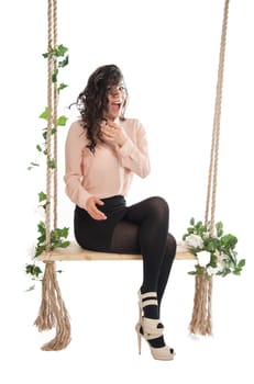 A woman in a pink blouse sitting on a swing isolated white background