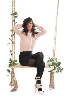 Woman joyfully shouts ruffled his hair, sitting on a swing.