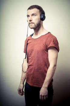 vintage portrait of fashion guy with headphones on gray background