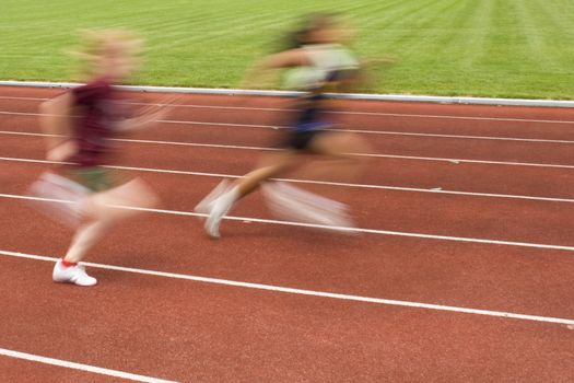 Blurred motion of two females racing on the track