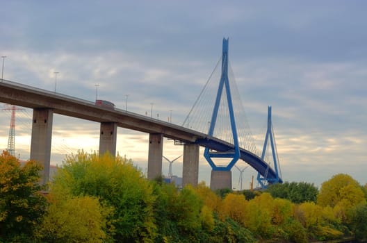 The Köhlbrandbrücke in the harbor district of hamburg in autumn. A bus is crossing.