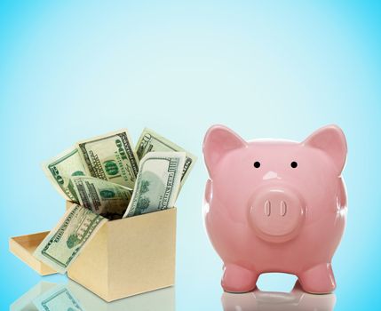 Pink Piggy bank with a box of money on a blue background