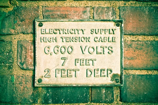 Old fashioned electric supply sign on a brick wall