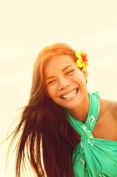 Sunshine smiling summer girl laughing happy looking at camera enjoying the summer sun sunset during holidays vacation. Young woman on Hawaiian beach. Pretty multicultural Asian Caucasian female model