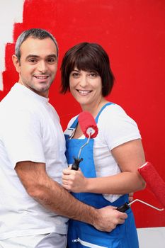 Couple painting a room bright red
