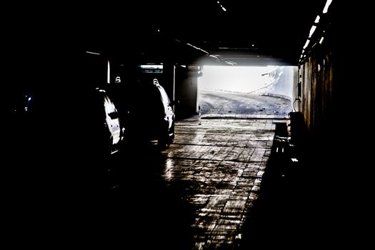 Generic photograph of daylight coming between the dark shadows of an under ground vehicle parking facility in Bombay, India
