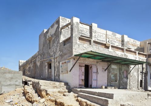 Dwarka Roadtrip February 27 2013. Landscape capture of typical architecture, looking as of ruins with open doors, striking blue sky with rubble, litter and half finished construction that seems typical of Indian culture. Location, Dwarka, Gujarat, India