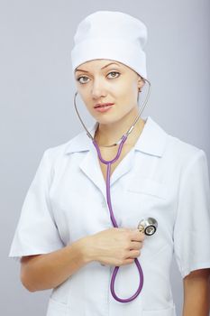 Young female doctor with stethoscope monitoring her heart