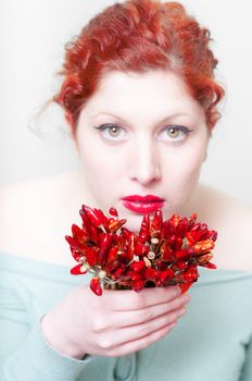 beautiful red hair and lips girl with red chillies on white background