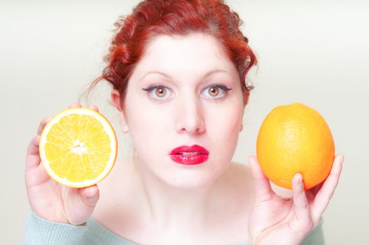 beautiful red hair and lips girl with oranges on white background