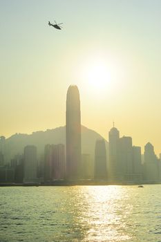 Helicopter in Hong Kong sky at sunset