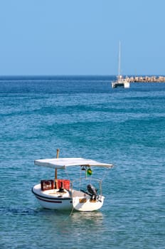 Fishing boat in foreground with catamaran in backgroun