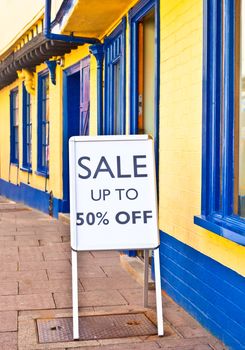 Sale sign outside a vibrant row of shops in England
