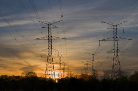 Electric towers through rural area at sunset