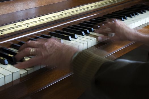 Showing movement with a slow shutter speed - old hands playing the piano